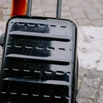 close-up of a hard-shell rolling suitcase