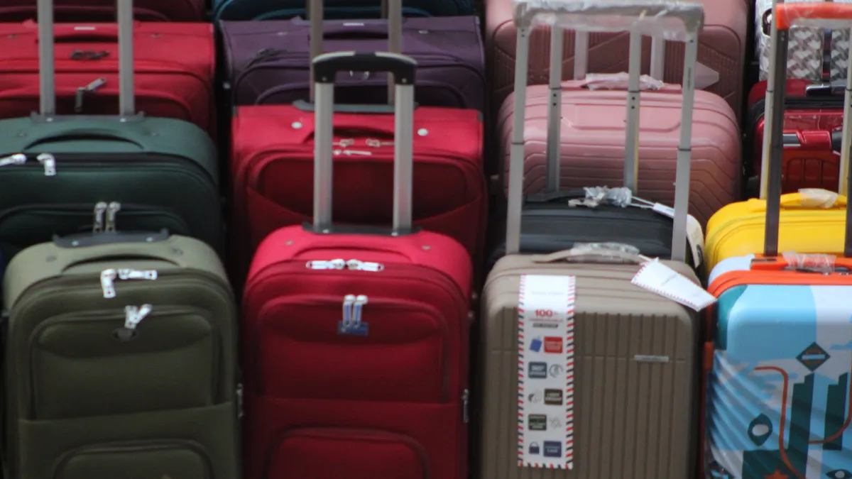 Best Luggage Features to Look For Before You Buy rows of upright suitcases with handles extended