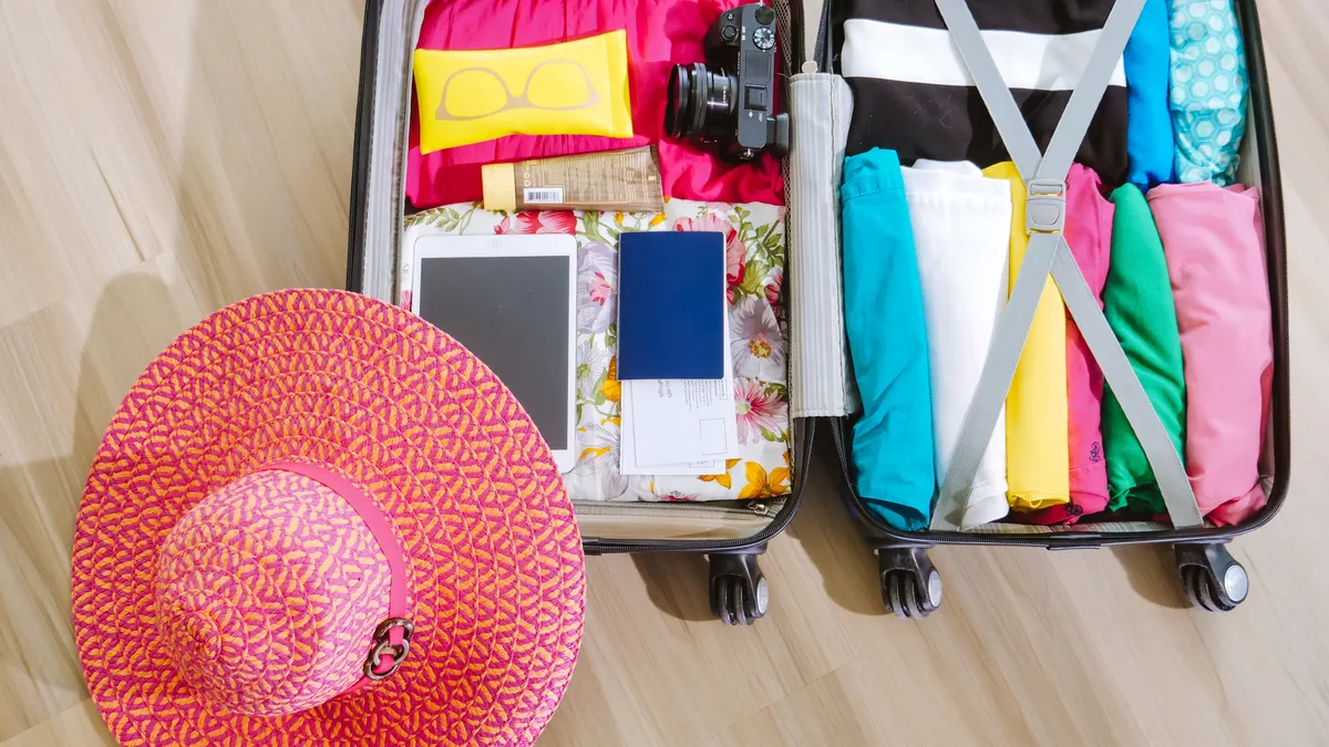 open suitcase packed with clothes and travel items